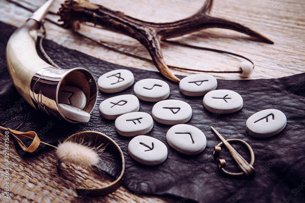 Rune nordiche e corno vichingo su tessuto scuro con corna di cervo - simboli della tradizione musicale e poetica scandinava