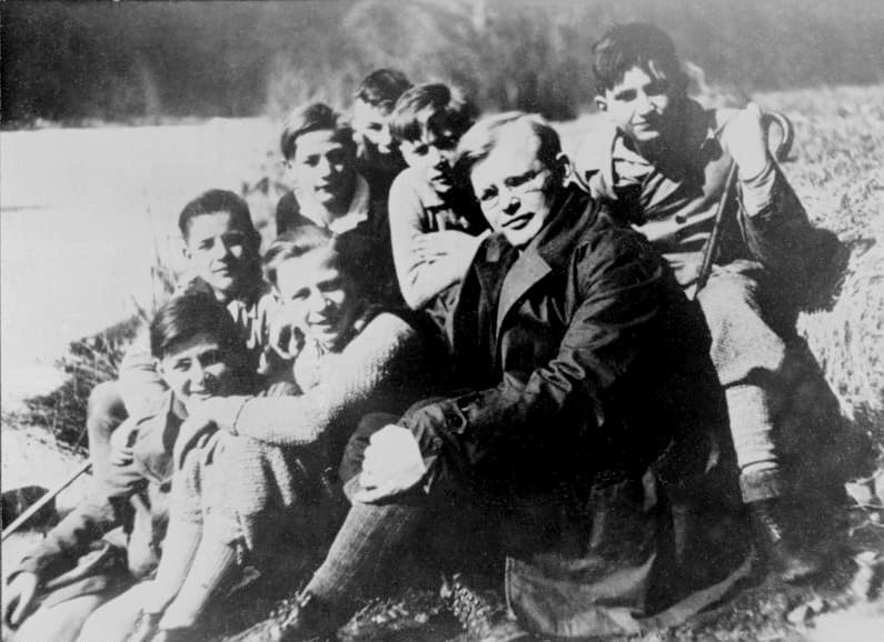 Dietrich Bonhoeffer seduto all'aperto con un gruppo di giovani allievi, fotografia degli anni Trenta
